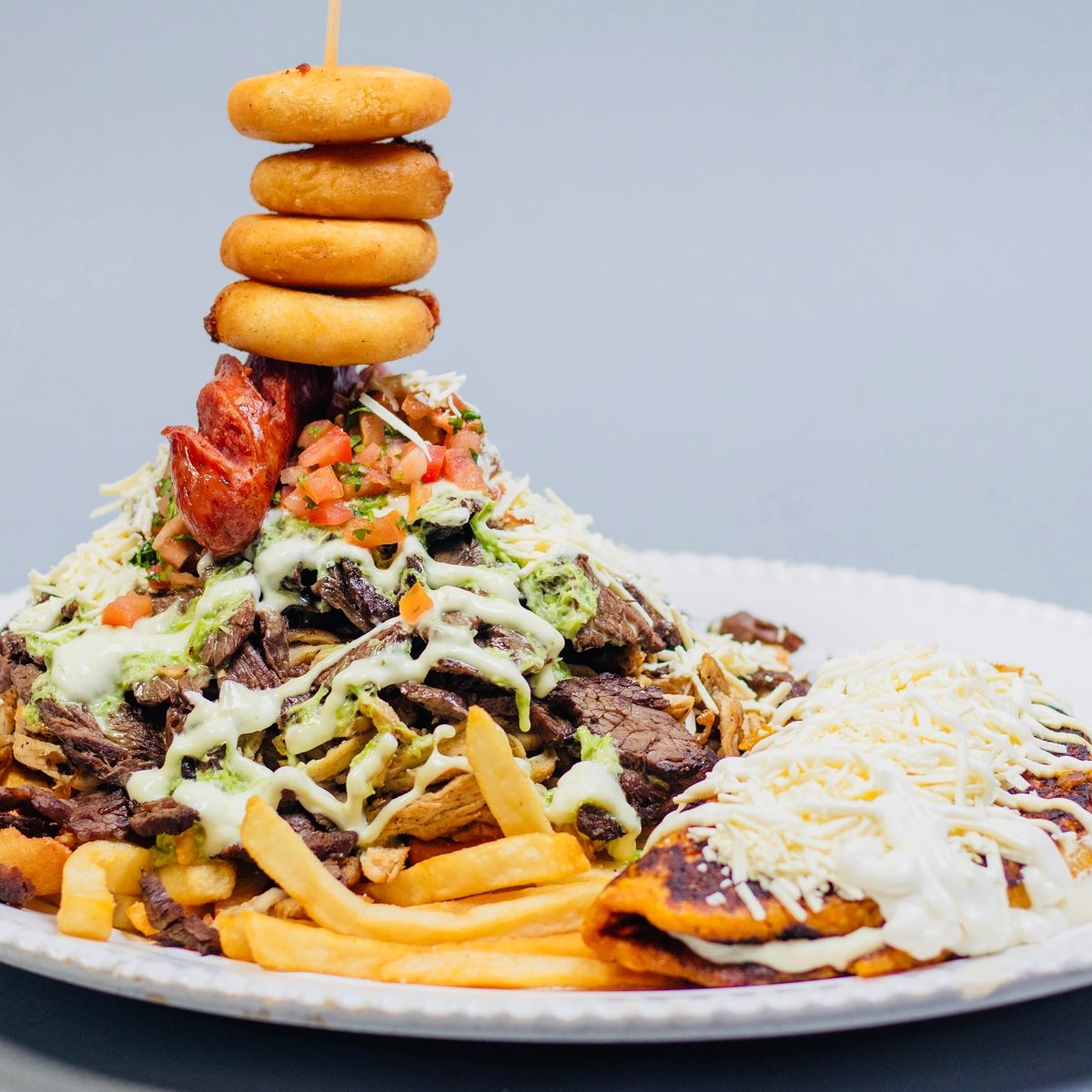Parrilla tower to share with onion rings, carne asada, chorizo and cheese at Pico e Gallo BBQ